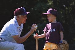 Coach and baseball player wearing our uniforms - Come to us for custom embroidery and screen-printing on your shirts, hats, and other apparel.